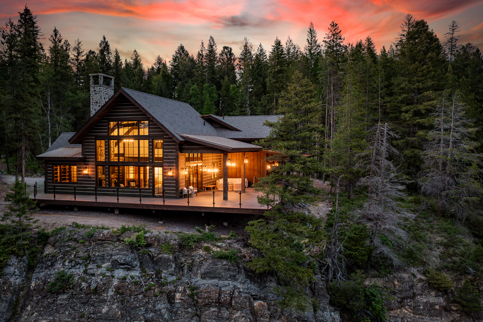 Contemporary architectural custom residence featuring stone masonry and copper detailing at sunset in Montana