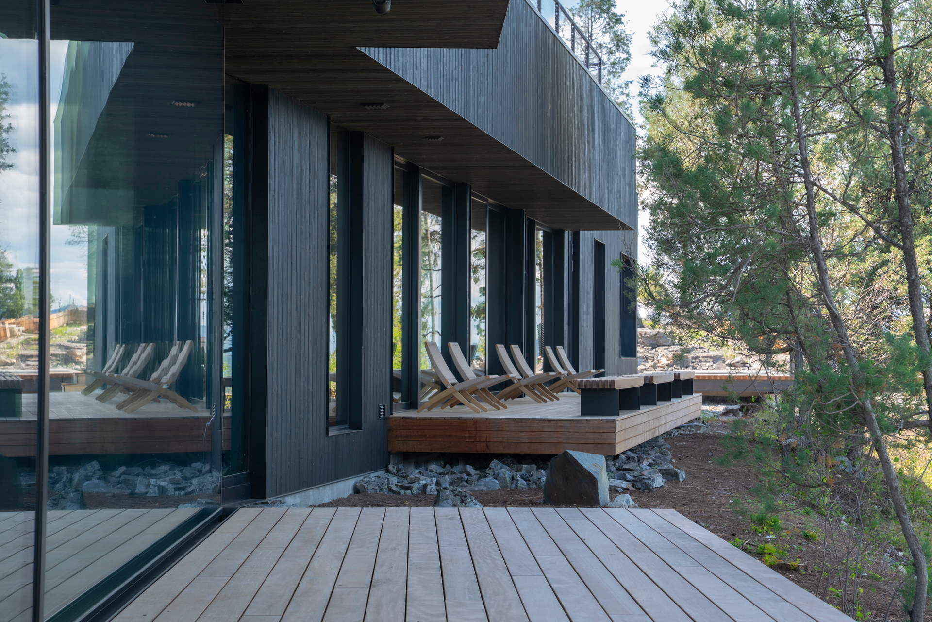 Contemporary architectural custom residence featuring stone masonry and copper detailing at sunset in Montana