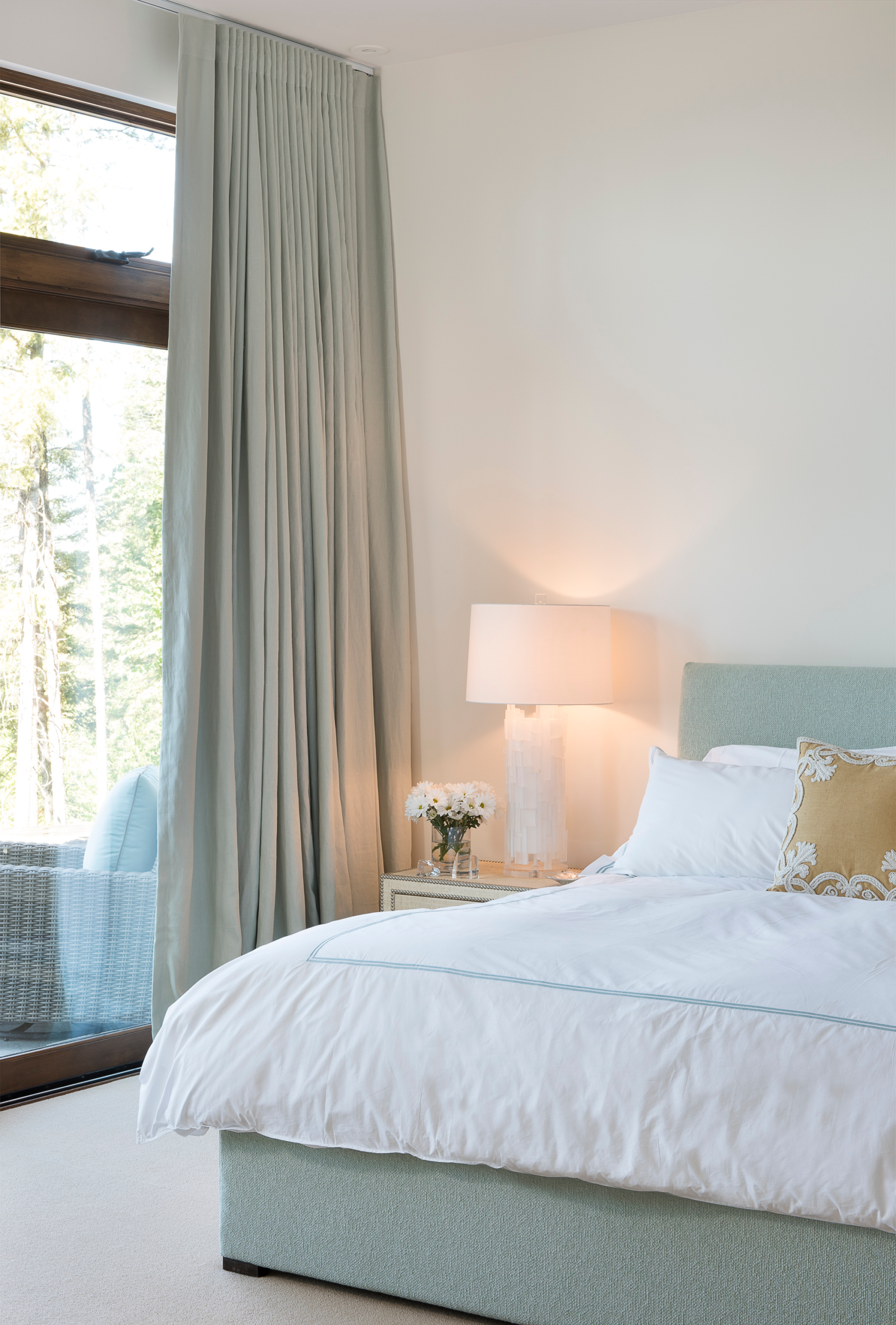 Primary suite bedroom with floor-to-ceiling windows facing mountain ranges