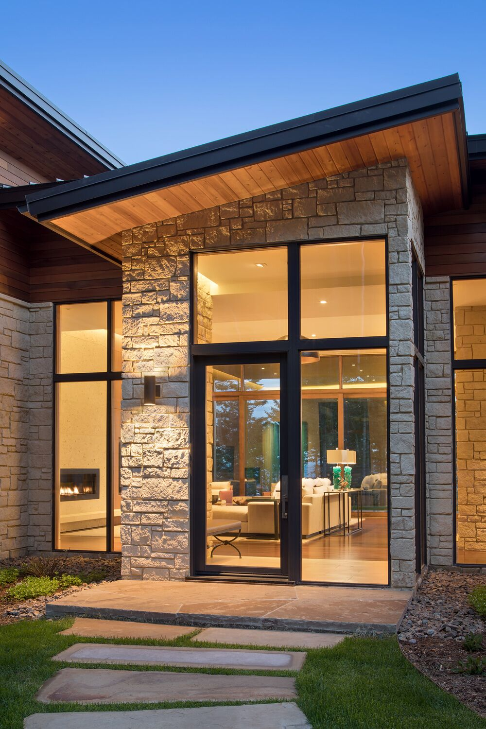 Oversized hand-crafted white oak and iron front pivot door with bronze hardware